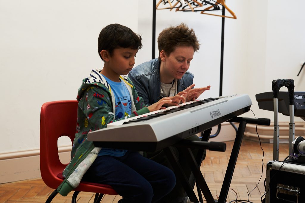 Student and teacher playing keyboard